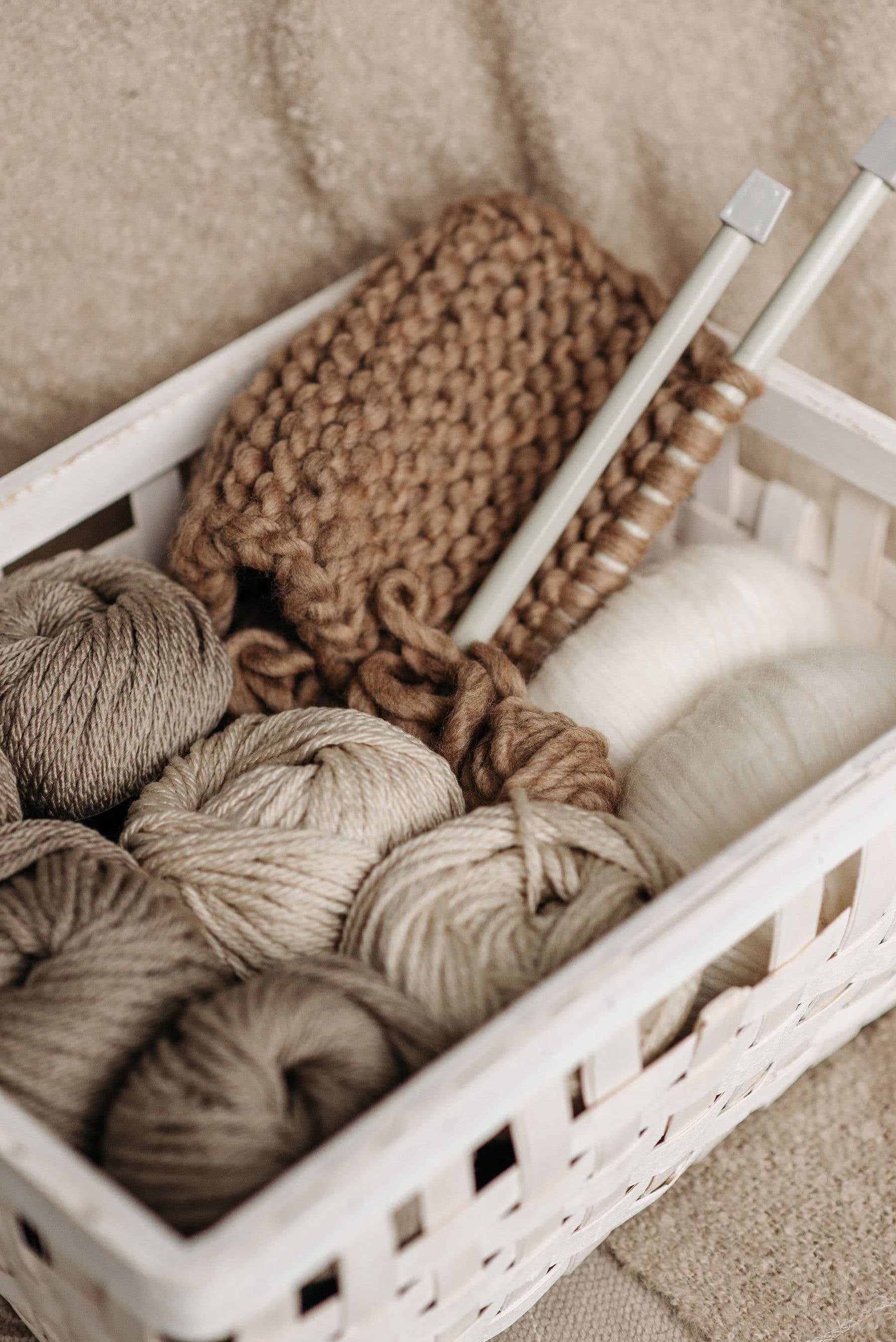 A basket of undyed wool and knitted work.